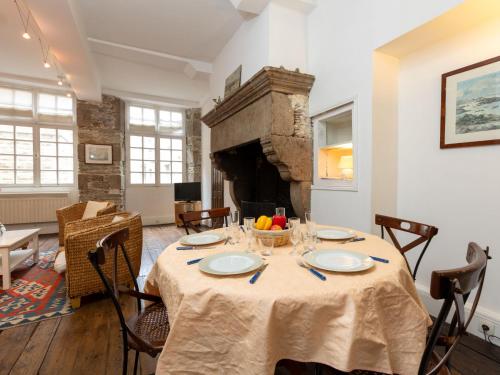 une salle à manger avec une table et une cheminée dans l'établissement Apartment Plijadur by Interhome, à Saint-Malo