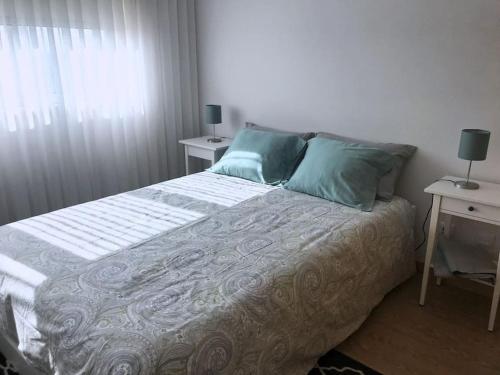 a bedroom with a bed with two tables and a window at Praia da Vagueira - Lights, Sea, Action! in Gafanha da Boa Hora