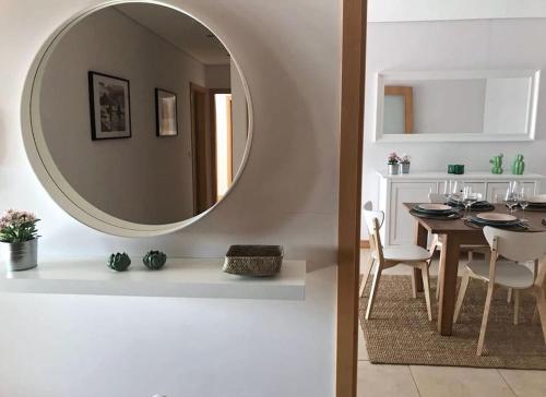 a dining room with a table and a mirror at Praia da Vagueira - Lights, Sea, Action! in Gafanha da Boa Hora