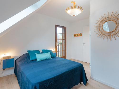 une chambre avec un lit bleu et un miroir dans l'établissement Holiday Home La Cour du Moulin-6 by Interhome, à Houlgate