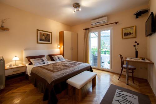 a bedroom with a bed and a sliding glass door at Villa Kamenica in Komiža