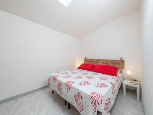 een witte slaapkamer met een bed met rode kussens bij Apartment L'appartamento nel Corso by Interhome in Carloforte