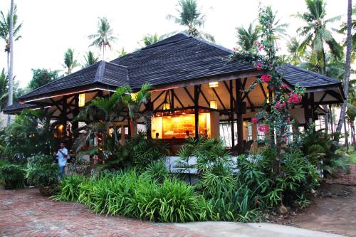 a building with a bunch of plants and flowers at Emerald Sea Resort in Ngwesaung