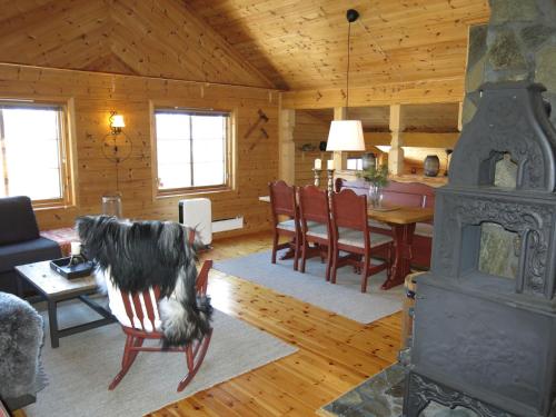 een woonkamer met een open haard en een eetkamer bij Chalet Mariabu - SOW142 by Interhome in Fossdal