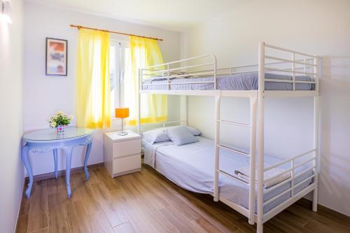 1 Schlafzimmer mit 2 Etagenbetten und einem Tisch in der Unterkunft Apartamento Buganvilla B5 in Son Bou