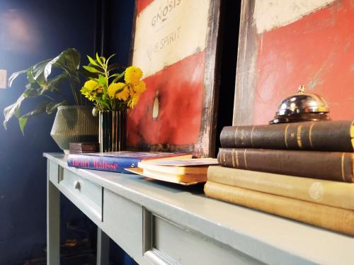 a shelf with books and a vase of flowers on it at Hotel Windsor Mendoza in Mendoza