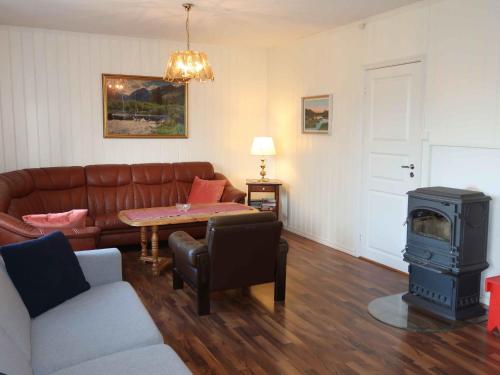 a living room with a couch and a stove at Holiday Home Anneks by Interhome in Sørbø