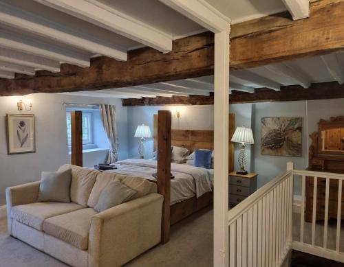 1 dormitorio con cama y sofá en Coves House Farm B&B en Wolsingham