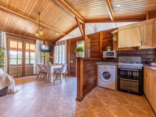 a kitchen with a washing machine and a dining room at Chalet Tropical 2 by Interhome in Riumar