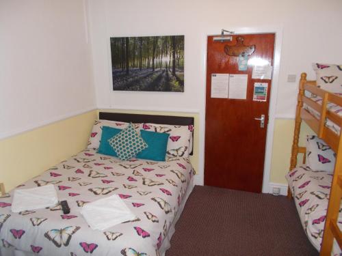 a bedroom with a bed and a door at Delamere Hotel in Blackpool