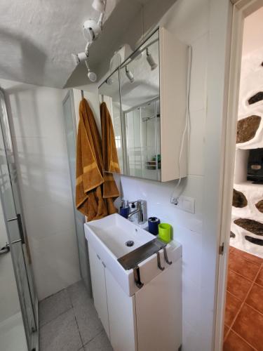 a white bathroom with a sink and a mirror at Casa Rural LOS PINARES El Juncal de TEJEDA in Tejeda