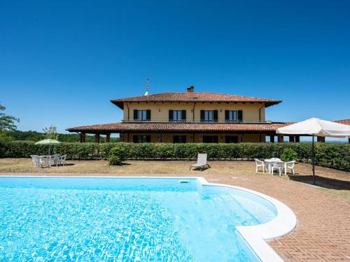 a house and a swimming pool in front of a house at Holiday Home Ex I vigneti del mandorlo by Interhome in Mombaruzzo