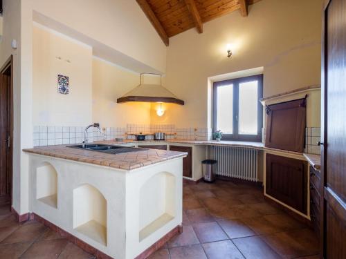 a large kitchen with a sink and a window at Holiday Home Lydia by Interhome in Mombaruzzo
