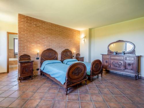 a bedroom with a bed and two chairs and a mirror at Holiday Home Lydia by Interhome in Mombaruzzo