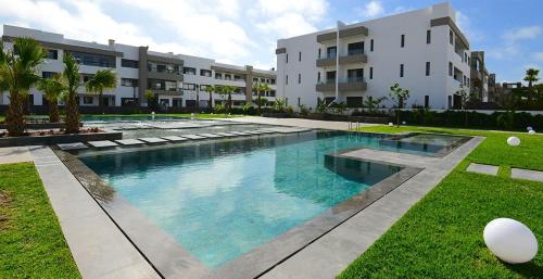 une grande piscine en face d'un bâtiment dans l'établissement Seaside - Luxury Living, à Dar Bouazza