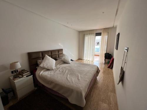 - une chambre avec un grand lit et une fenêtre dans l'établissement Seaside - Luxury Living, à Dar Bouazza