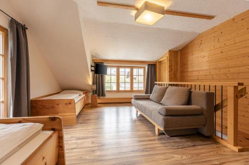 a room with a couch and a bed and a chair at Alm Chalet Grosseck in Mariapfarr