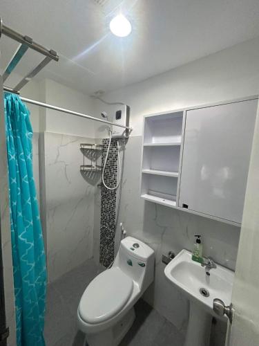 a bathroom with a toilet and a sink at Victoria Sports Tower in Manila