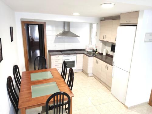 a kitchen with a table and chairs and a refrigerator at Piso en Playa de Gandía! in Gandía