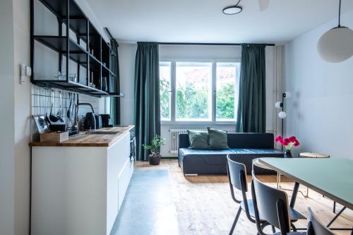 eine Küche und ein Wohnzimmer mit einem blauen Sofa in der Unterkunft Flattering - Berlin in Berlin