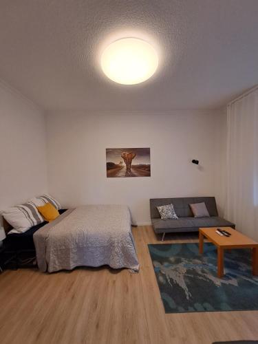 een slaapkamer met een bed, een bank en een tafel bij Velbert am Berg in Velbert