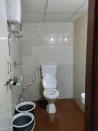 baño con aseo y 2 cubos en KUKKE GUEST ROOM, en Subrahmanya