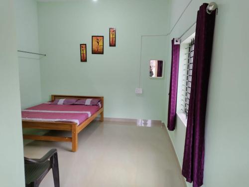 KUKKE GUEST ROOM في Subrahmanya: غرفة نوم مع سرير ونافذة مع ستائر أرجوانية