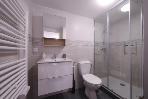 a white bathroom with a toilet and a shower at Cœur de vieille ville in Gex