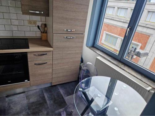 une cuisine avec une table en verre et une fenêtre dans l'établissement The Bachelor Backpacker Spot, à Bruxelles