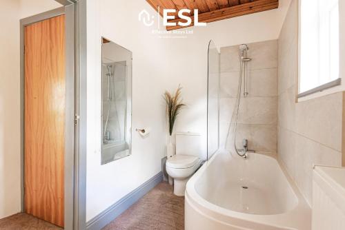 a white bathroom with a toilet and a bath tub at 3 Bedroom House - Overlooking River - Shrewsbury Town Centre in Shrewsbury