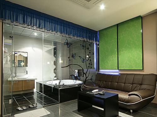 a living room with a couch and a glass shower at JJ Hotel in Seoul