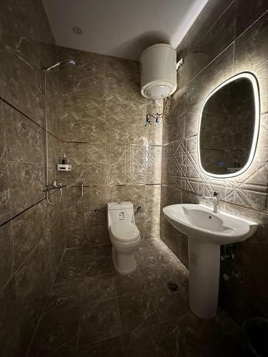 a bathroom with a toilet and a sink at شقة مودرن في حي العقيق in Riyadh