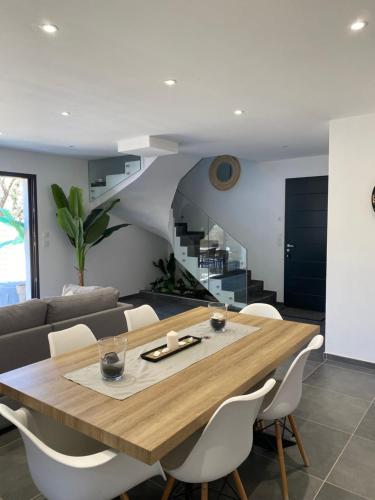 une salle à manger avec une table et un canapé dans l'établissement Maison/jacuzzi à 5 min de la mer, au Pradet
