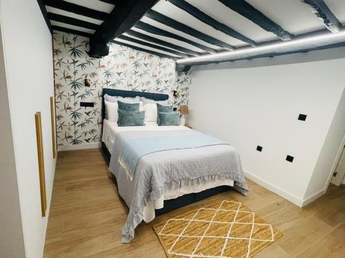 a bedroom with a bed with a blue comforter at Apartamento Magdalena 2 in Oviedo