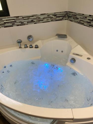 d'une baignoire remplie d'eau et de lumières bleues. dans l'établissement Maison/jacuzzi à 5 min de la mer, au Pradet