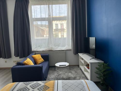 une chambre bleue avec un canapé et une fenêtre dans l'établissement Sofieflat - Wallifornie, à Charleroi