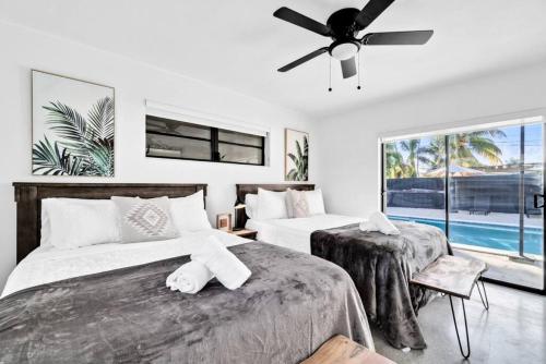 a bedroom with two beds and a ceiling fan at Modern Pool Home Great for Families in Hollywood