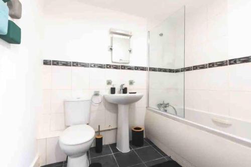 La salle de bains est pourvue de toilettes, d'un lavabo et d'une baignoire. dans l'établissement Exquisite Luxury Retreat, à Southampton