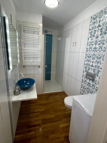 a bathroom with a toilet and a sink and a shower at Apartament Szczytno in Szczytno