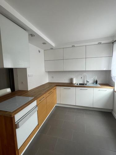 a kitchen with white cabinets and a sink at Apartament Szczytno in Szczytno