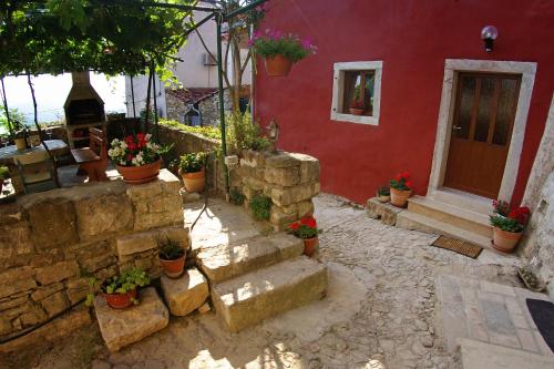 a red house with potted plants in front of it at Guesthouse Villa Marija in Motovun