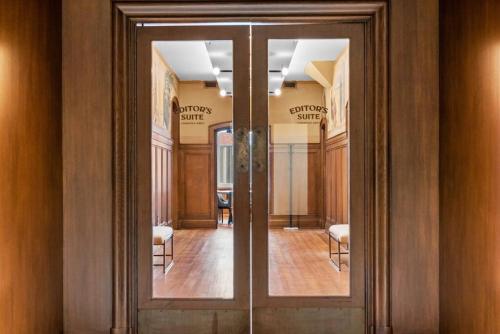 a hallway with glass doors with chairs in a room at Journal Commons 332 Lavish 1BR at Historic Journal Sentinel 65 TV in Milwaukee