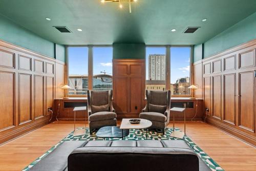 a room with two chairs and a table and windows at Journal Commons 332 Lavish 1BR at Historic Journal Sentinel 65 TV in Milwaukee