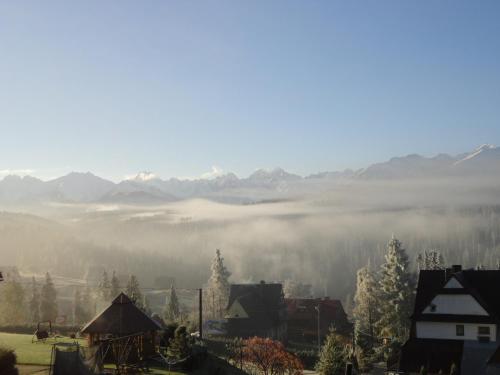 a view of a foggy valley with mountains in the background at Willa Roztoka & SPA - idealne miejsce dla Twojej rodziny in Bukowina Tatrzańska