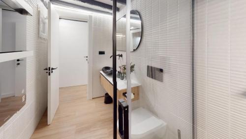 a bathroom with a sink and a toilet and a mirror at Apartamento Magdalena 2 in Oviedo