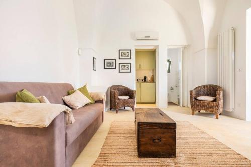 a living room with a couch and chairs and a table at The Peak House in Carovigno