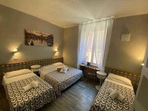 ローマにあるGUEST HOUSE FIDARDOのベッド2台と窓が備わるホテルルームです。