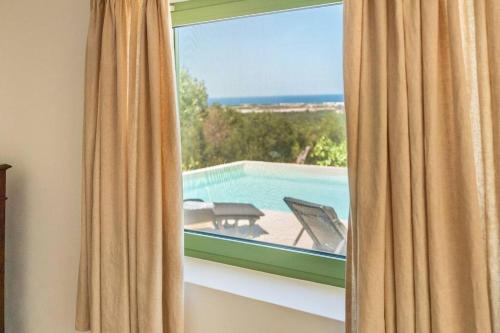 a window with a view of a swimming pool at The Peak House in Carovigno