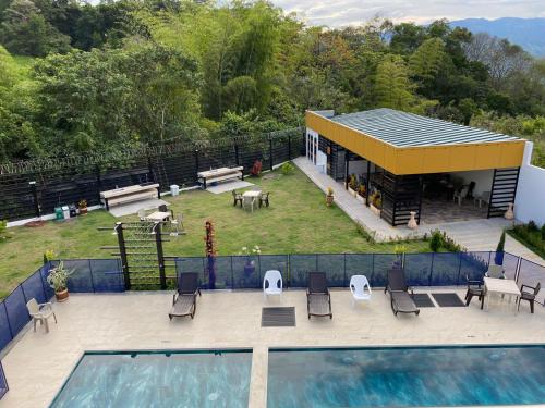 a house with a swimming pool and a patio with chairs at HOTEL ISIS CONFORT in La Mesa