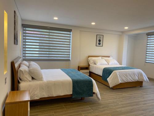 um quarto com 2 camas e uma janela em HOTEL ISIS CONFORT em La Mesa